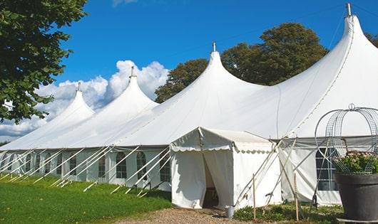 tall green portable restrooms assembled at a music festival, contributing to an organized and sanitary environment for guests in Wanatah